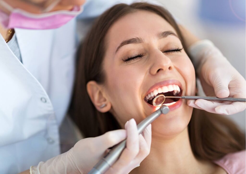 Dentist examining a patient's teeth during a routine checkup to identify early cavities and discuss whether tooth decay can heal naturally.