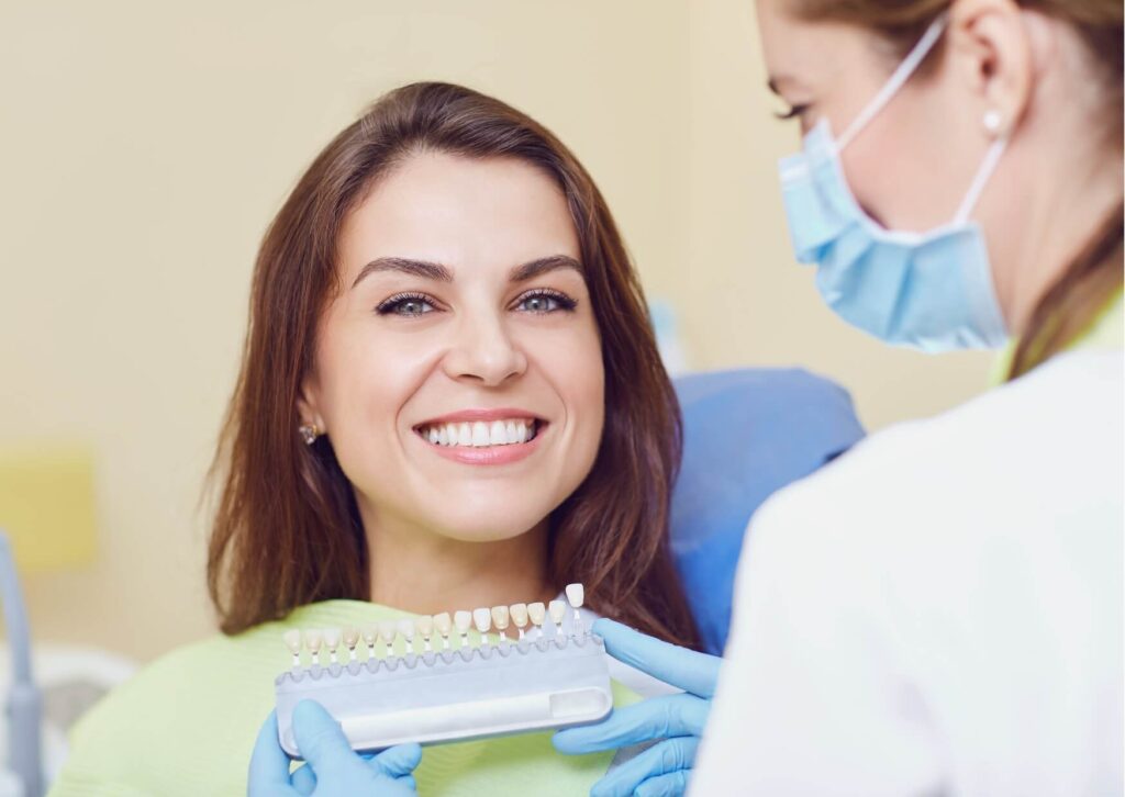 Patient reviewing veneer shade options with a cosmetic dentist, highlighting how porcelain veneers can maintain a natural appearance for many years.
