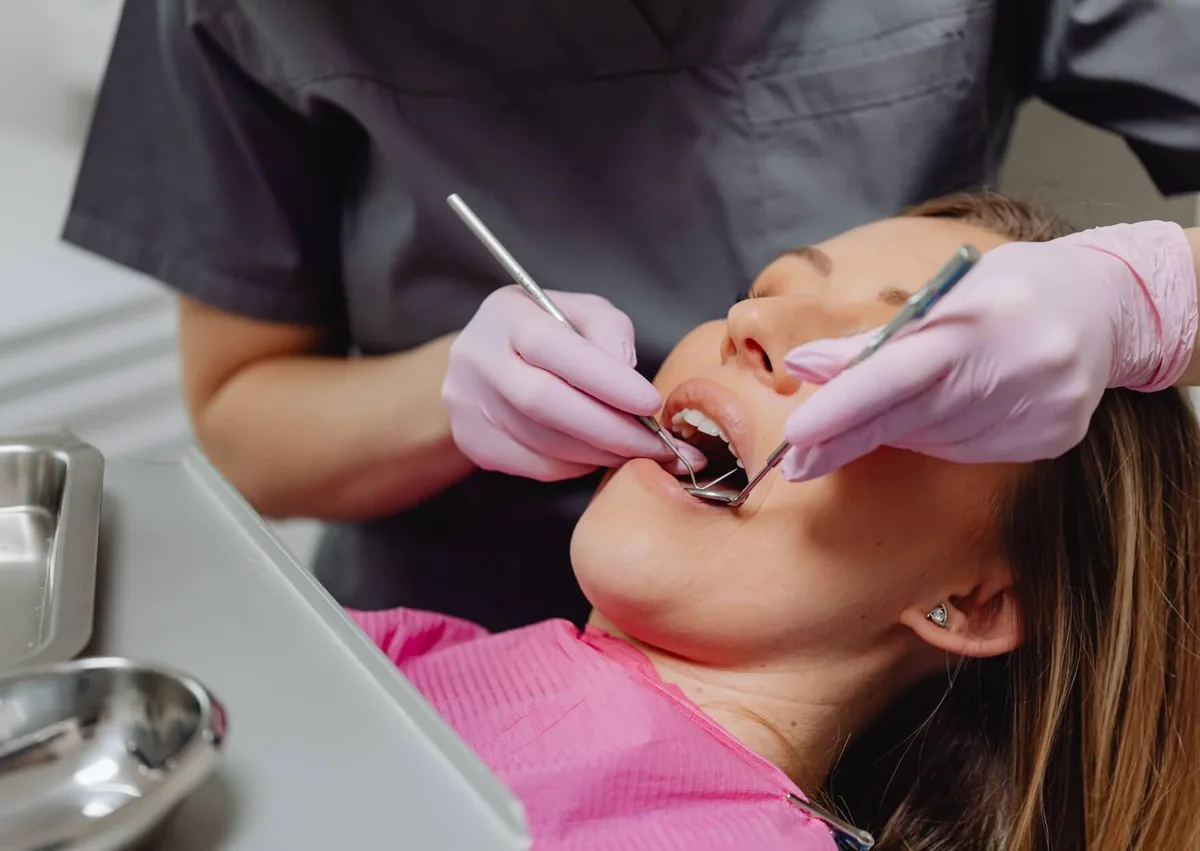 Dentist examining a patient to evaluate their oral health for full mouth dental implants.