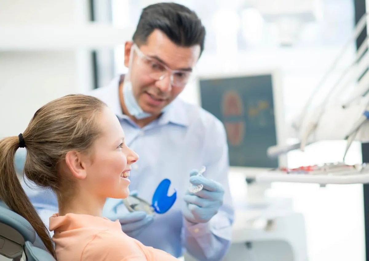Orthodontist discussing braces treatment and cost options with a young patient.