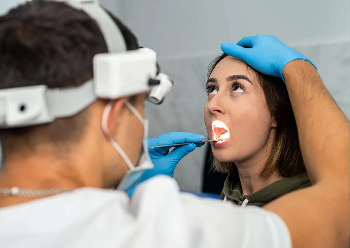 Dentist examining a patient’s mouth for signs of oral thrush and other oral health concerns.