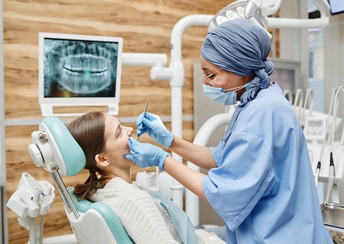 Dentist examining a patient’s teeth and gums during a consultation for gummy smile treatment.