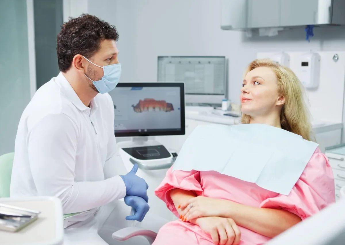 Dentist discussing the number of adult teeth with a patient during a dental consultation.