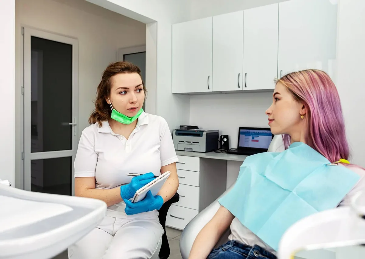 Dental professional discussing dietary guidelines and avoiding dairy after dental implant surgery with a patient.